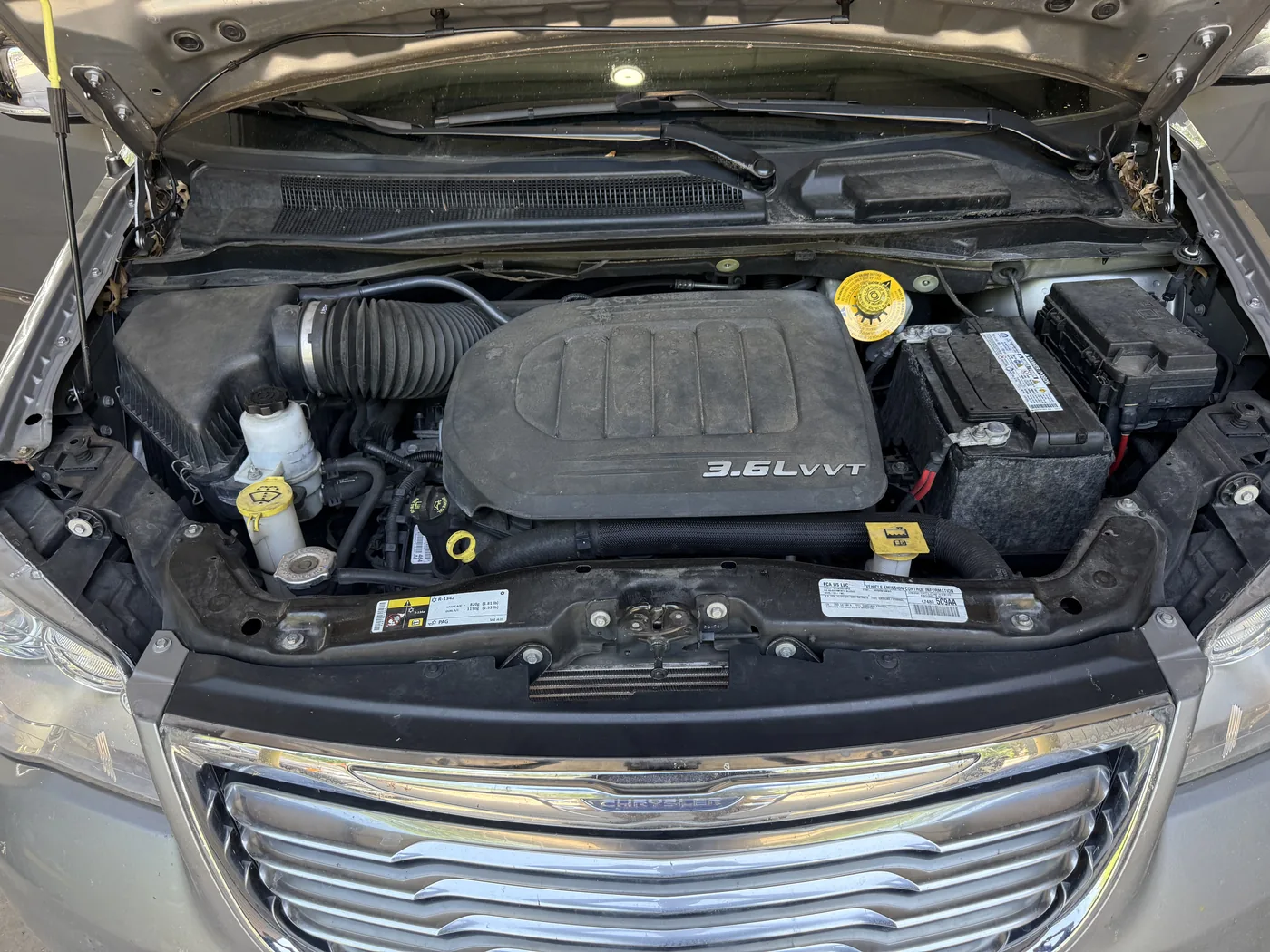 Chrysler 3.6 liter engine bay at check-in, covered in dust and road film